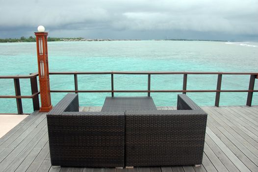 Brown couch at timber pier with ocean view, Maldives