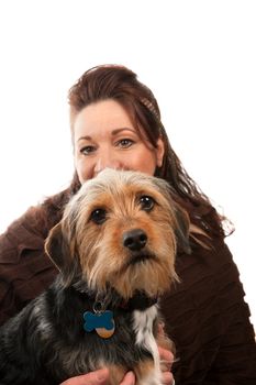 A middle aged woman isolated over white holding a cute mixed breed Borkie dog.