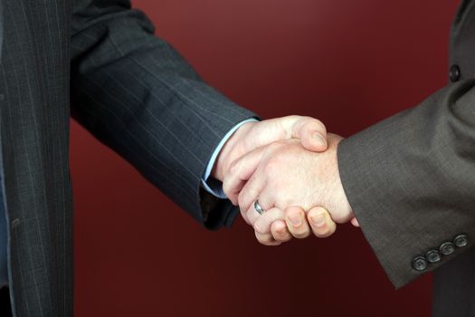 Business negotiations illustrated with a close up of a handshake between two men.