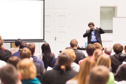 Speaker Giving a Talk at Business Meeting. Audience in the conference hall. Business and Entrepreneurship. Copy space on white board.