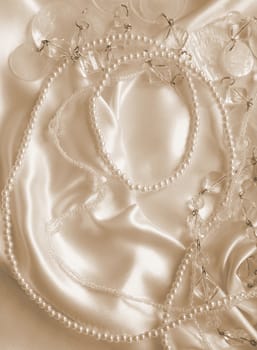 Pearls and nacreous beeds on silk or satin as wedding background. In Sepia toned. Retro style