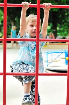 boy climbing wall bars on the playground