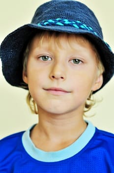 portrait of boy wearing blue straw hat