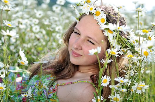 beauty spring teen girl with garland from daisies 