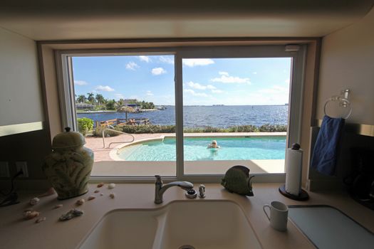 Looking through a window to a pool area with woman in the pool