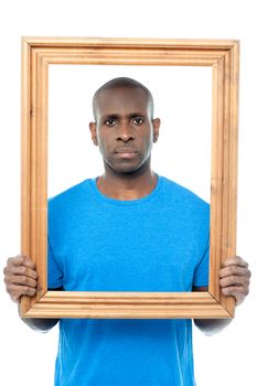 Man standing behind wooden picture frame