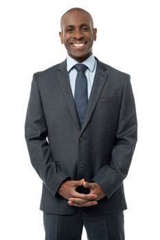 African businessman standing with his hands clasped and smiling