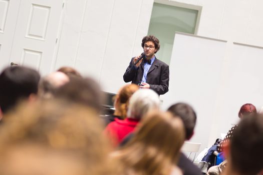 Speaker Giving a Talk at Business Meeting. Audience in the conference hall. Business and Entrepreneurship. Copy space on white board.