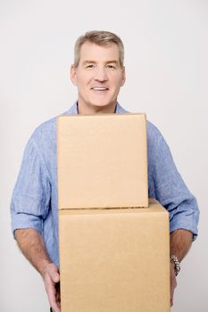 Middle aged man carrying stack of carton boxes