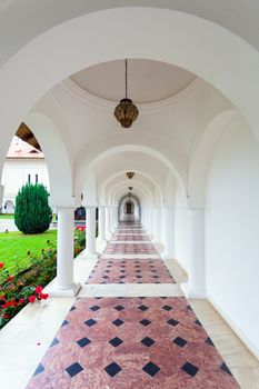 Arched colonade hallway at Sambata de Sus monastery in Transylvania, Romania