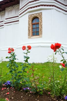 Flowers in front of Sambata de Sus Church inside Monastery courtyard in Transylvania, Romania
