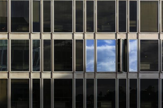 sky and clouds reflected on the windows of a building after a thunderstorm