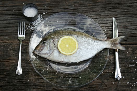 Raw fish on plate with knife and fork