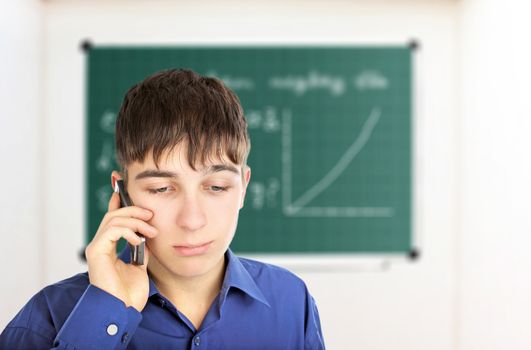 Sad Teenager with Cellphone in the Classroom