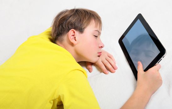 Tired Kid with Tablet Computer on the Bed