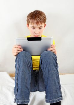 Sad Kid with Tablet Computer on the White Background