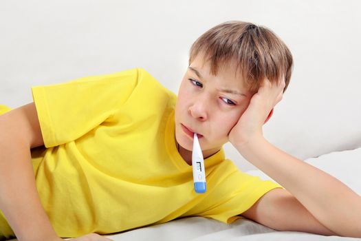 Sick Kid with Thermometer on the Bed