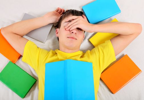 Tired Teenager sleep with a Books on the Bed