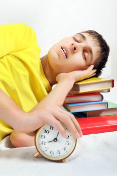 Teenager sleep on the Books with Alarm Clock