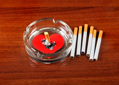 Cigarette in Ashtray with Heart Shape on the Table