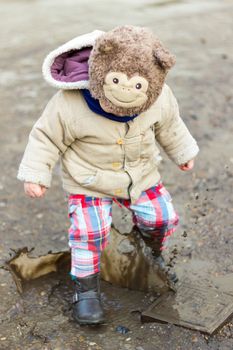 Kid playing in puddle on city street