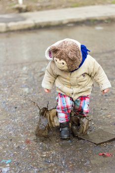 Kid playing in puddle on city street