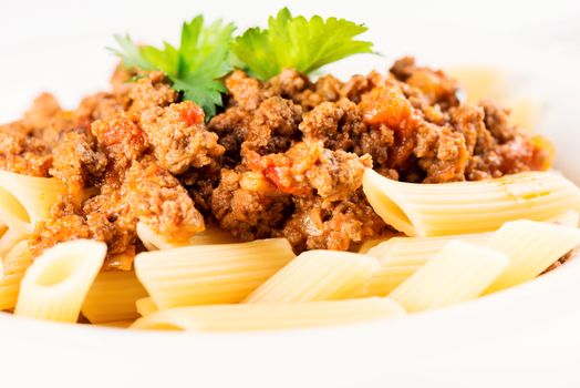 Pasta. Penne Pasta with Bolognese Sauce, Parmesan Cheese and Basil, Fork. Italian Cuisine. Mediterranean food