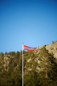 Norwegian pennant on a pole with mountains background