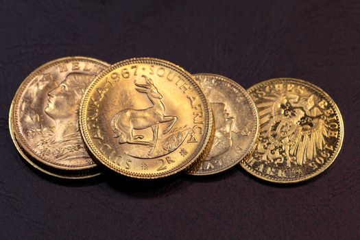 Old gold coins on a dark background.