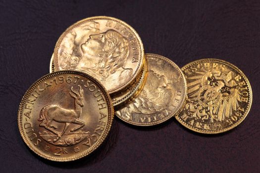 Old gold coins on a dark background.