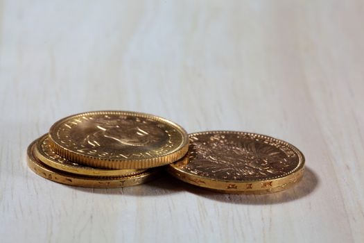 Old gold coins on a wood background