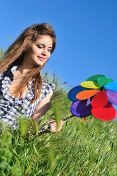 happy cute teen girl having fun with windmill in the field 