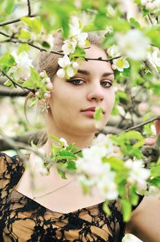 beautiful teen girl standing in the apple blossom 