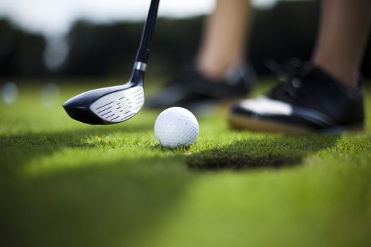 Girl playing golf on grass in summer