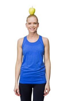 blonde smiling woman wearing fitness clothing holding an apple on her head