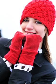 girl wearing reg hat and red gloves outdoors 