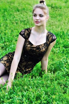 stunning beauty girl sitting in the high green grass 