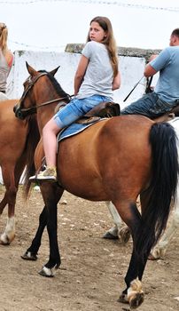 teen longhaired girl sitting on the horse 