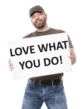 A bearded man holding a white board with the message love what you do