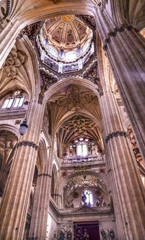 Stone Columns Angels Dome Stained Glass New Salamanca Cathedral Spain.  The New and Old Cathedrals in Salamanca are right next to each other.  New Cathedral was built from 1513 to 1733 and commissioned by Ferdinand V of Castile, Spain.