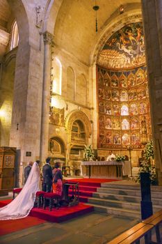 Marriage Groom Bride White Wedding Dress Ancient Apse House Old Salamanca Cathedral Castile Spain. 52 tablets completed in 1400s, 12 of which by Diego Delli, Italian artist, celebrating life of Jesus and Mary with fresco of final judgment above them.  Old Salamanca Cathedral next to the new Salamanca Cathedral is known as Catedral Vieja de Santa Maria.  Founded by Bishop Jerome of Perigold in the 1100s.  It was finished in the 1300s and dedicated to Saint Mary of the See 