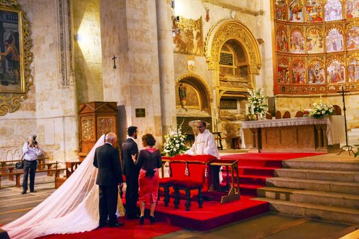 Marriage Groom Bride White Wedding Dress Ancient Apse House Old Salamanca Cathedral Castile Spain. 52 tablets completed in 1400s, 12 of which by Diego Delli, Italian artist, celebrating life of Jesus and Mary with fresco of final judgment above them.  Old Salamanca Cathedral next to the new Salamanca Cathedral is known as Catedral Vieja de Santa Maria.  Founded by Bishop Jerome of Perigold in the 1100s.  It was finished in the 1300s and dedicated to Saint Mary of the See 