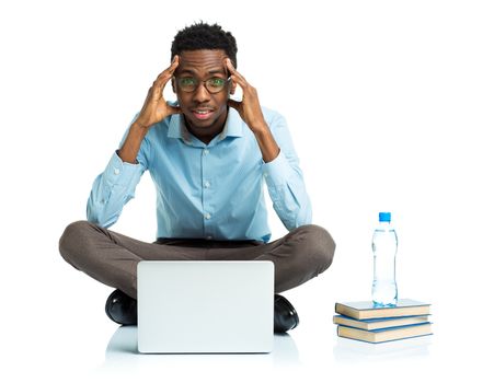 Happy african american college student with laptop, books and bottle of water sitting on white background