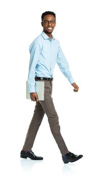 Happy african american college student with laptop standing on white background