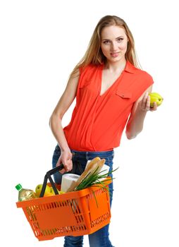 Happy young woman holding a basket full of healthy food. Shopping