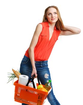 Happy young woman holding a basket full of healthy food. Shopping