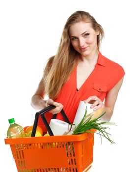 Happy young woman holding a basket full of healthy food. Shopping