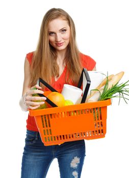 Happy young woman holding a basket full of healthy food. Shopping