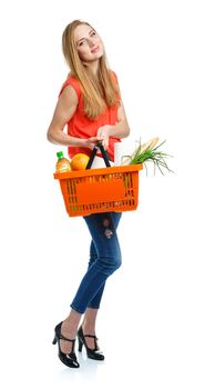 Happy young woman holding a basket full of healthy food. Shopping