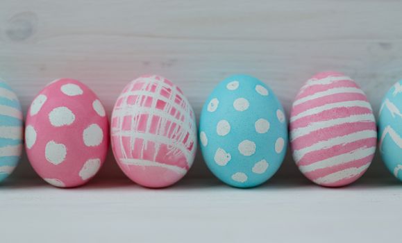 Pink and blue easter eggs on a wooden background